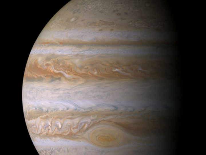 Jupiter's banded globe in cream, tan and brown stripes with the Great Red Spot in the lower half