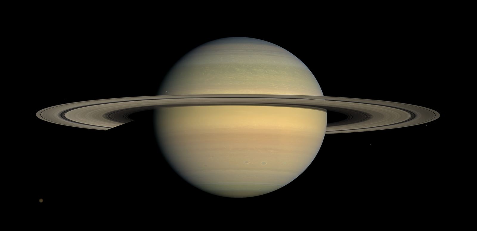Saturn with its broad, thin rings seen nearly edge-on from Cassini, casting a narrow shadow across the planet